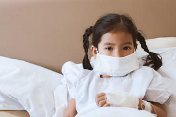 Sick asian little child girl wear protection mask while live in the hospital