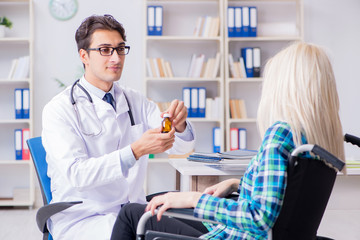 Obraz premium Disabled woman in wheel chair visiting man doctor