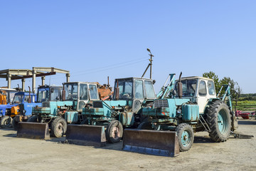 Tractor with a bucket for digging soil. Bulldozer and grader.