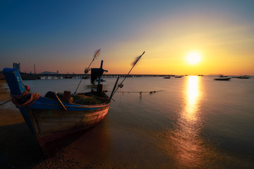 Fototapeta na wymiar Fishing boat in on the beach at sunset.