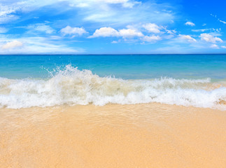 Fototapeta na wymiar Picturesque view of Andaman sea with strong and high waves in Phuket island, Thailand. Seascape with yellow sand and blue sky. Tropical beach at the exotic island.