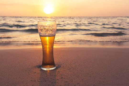 Glass Of Cold Beer On The Sea Shore At The Sunset. Relax On The Beach.