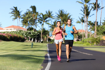 Sport fitness runners couple running lifestyle. Healthy people jogging together in summer city street outdoor, athletes training cardio in residential neighborhood.