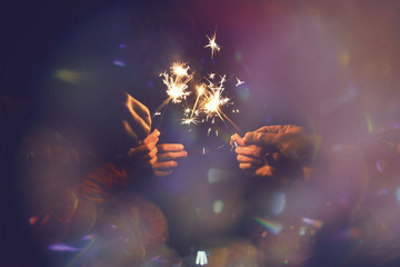 Picture showing group of hand having fun with sparklers.