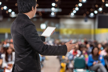 Rear view of Business People Conference Speaker on over the Abstract blurred photo of conference hall or seminar room with attendee background, business seminar and education concept