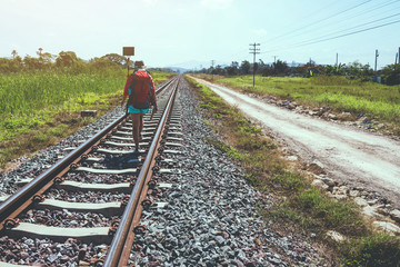 Asian women travel countryside. Travel relax. bag backpack travel. Walk on the railroad. Thailand