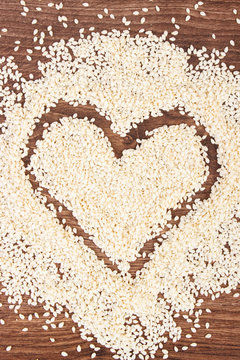 Heart of sesame seeds on board, healthy nutrition concept and sumbol of love
