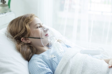 Girl with respiratory mask equipment in hospital. Healthcare and medical concept.