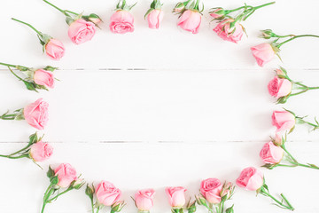 Fototapeta na wymiar Flowers composition. Frame made of pink rose flowers on white wooden background. Flat lay, top view, copy space