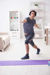 Obraz premium Man doing sports at home and listening to music