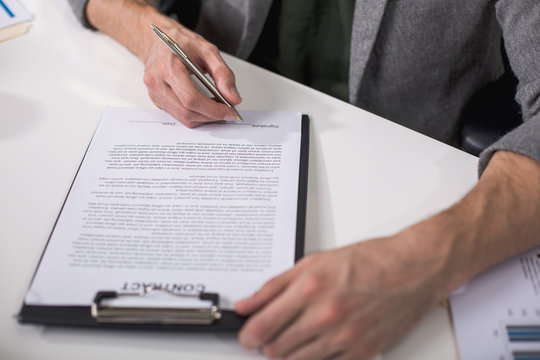 Great deal. Close up of male hands underwriting documents with pen