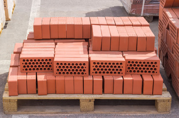 Red perforated bricks on pallet on an outdoor warehouse