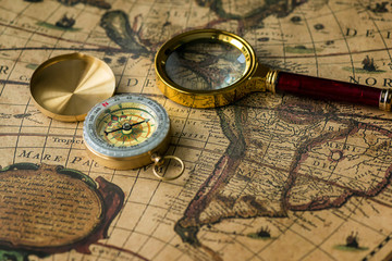 Retro compass with old map and magnifier