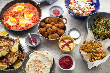 Overhead image of traditional jewish and middle eastern food: falafel, fattoush, tabouli,...