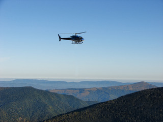 Fototapeta na wymiar Blue helicopter flying on blue sky