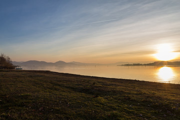 Beautiful sunset on Trasimeno lake (Umbria, Italy) with sun coming down behind Polvese island