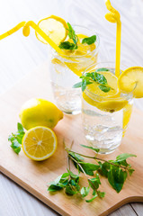 Glasss of mojito with lemon and drinking straw