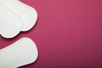 Set of menstruation pads on a red background, blank space for text.