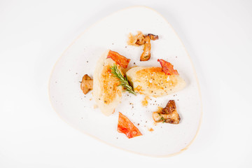Traditional polish dish called kartacz - potato dumplings stuffed with meat and served with crispy bacon, caramelized onion and fried boletus