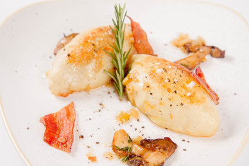 Traditional polish dish called kartacz - potato dumplings stuffed with meat and served with crispy bacon, caramelized onion and fried boletus