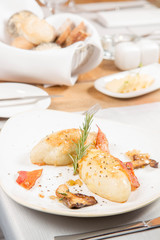 Traditional polish dish called kartacz - potato dumplings stuffed with meat and served with crispy bacon, caramelized onion and fried boletu