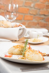 Traditional polish dish called kartacz - potato dumplings stuffed with meat and served with crispy bacon, caramelized onion and fried boletu