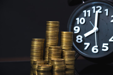 Coins stacks and alarm clock with tablet computer and financial graph, business planning vision and finance analysis concept