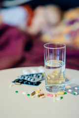 medicines on the table and a glass of water