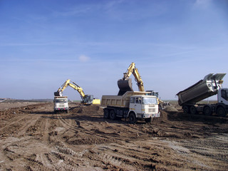 Excavators load trucks