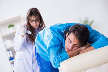 Funny man getting ready for buttocks syringe shot