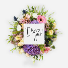 Fresh flowers bunch and card with words i love you written on it