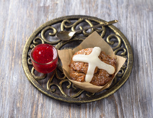 Easter cross muffins with raisins, cranberries and raspberry jam on a wooden table