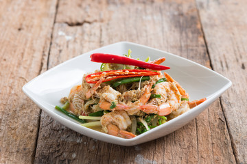 Stir-Fried Shrimp with Curry Powder in white plate on brown wood background
