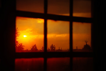 Landscape: fiery, bright sunset in the window