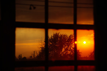 Landscape: fiery, bright sunset in the window