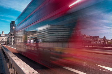 Fototapeta na wymiar London bus speeds across London Bridge