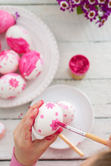 The girl paints Easter eggs
