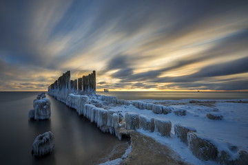 Frozen wooden breakwaters line to the world war II torpedo platform at Baltic Sea, Babie Doly,...