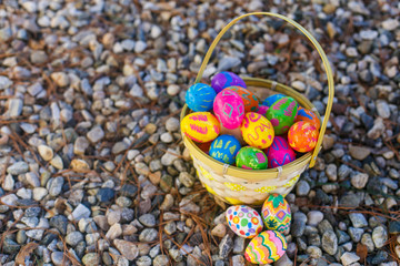 Easter eggs in the basket lie on the pebbles