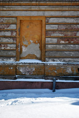 Mortgaged window of the old brick building with cracked plaster, winter snowy street,  grunge vertical background