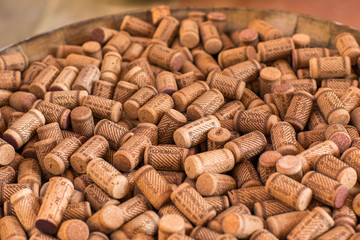 Background texture of a randomly scattered pile of assorted used wine corks with cultivar and winery details on the surface of the corks.