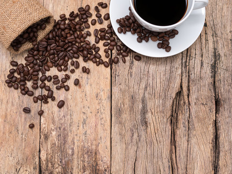 coffee cup and coffee beans on wooden background with copy space, top view. coffee picture background for coffee shop or cafe business.