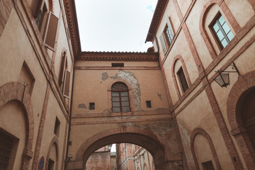 Fototapeta na wymiar Archway between two buildings in historical quarter of Siena
