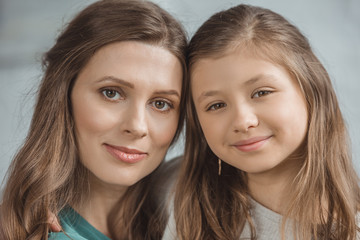 portrait of mother and daughter looking at camera