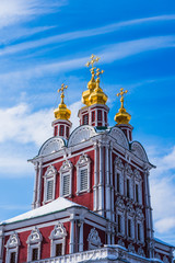 Fototapeta na wymiar Golden domes with crosses of old orthodox church on a background of beautiful blue sky