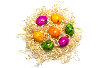 Colored eggs on packing straw. Isolated. Easter 2018. Top view