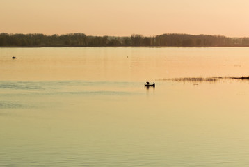 Fishermen in a rowing boat swim early in the spring on fishing on the Volga River