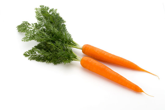 Carrot vegetable with leaves on the wooden background.