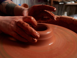 Forming a clay mug on a potter's wheel.