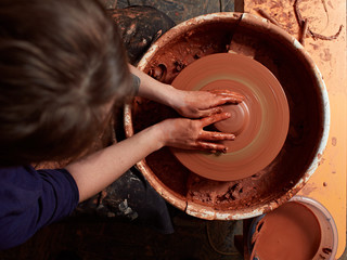 production process of pottery. Forming the clay cover of the kettle on the potter's wheel.